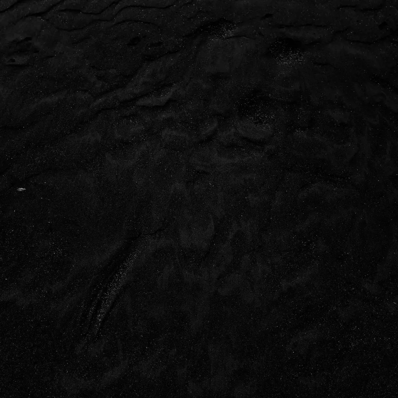 a black and white photo of water and sand