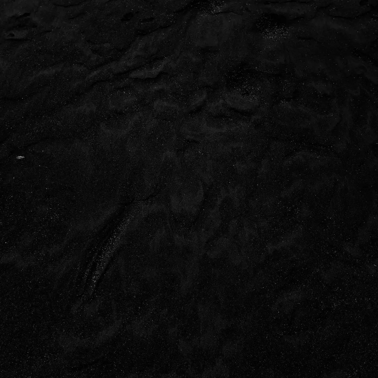 a black and white photo of water and sand